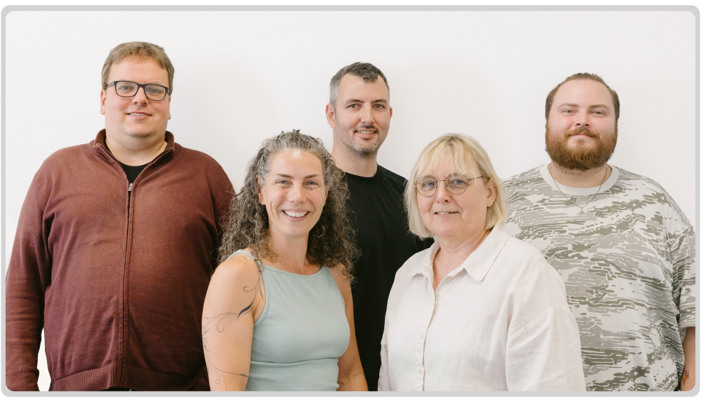 Das Team der Geschäftsstelle des TV Stuhr: Fünf lächelnde Mitarbeiterinnen und Mitarbeiter vor einem weißen Hintergrund.